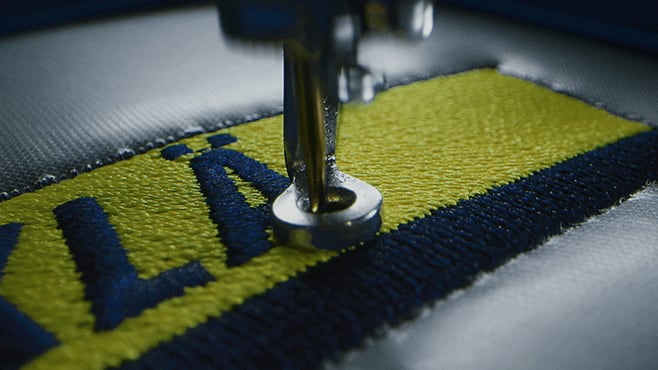 Borduurmachine die een logo op werkkleding borduurt